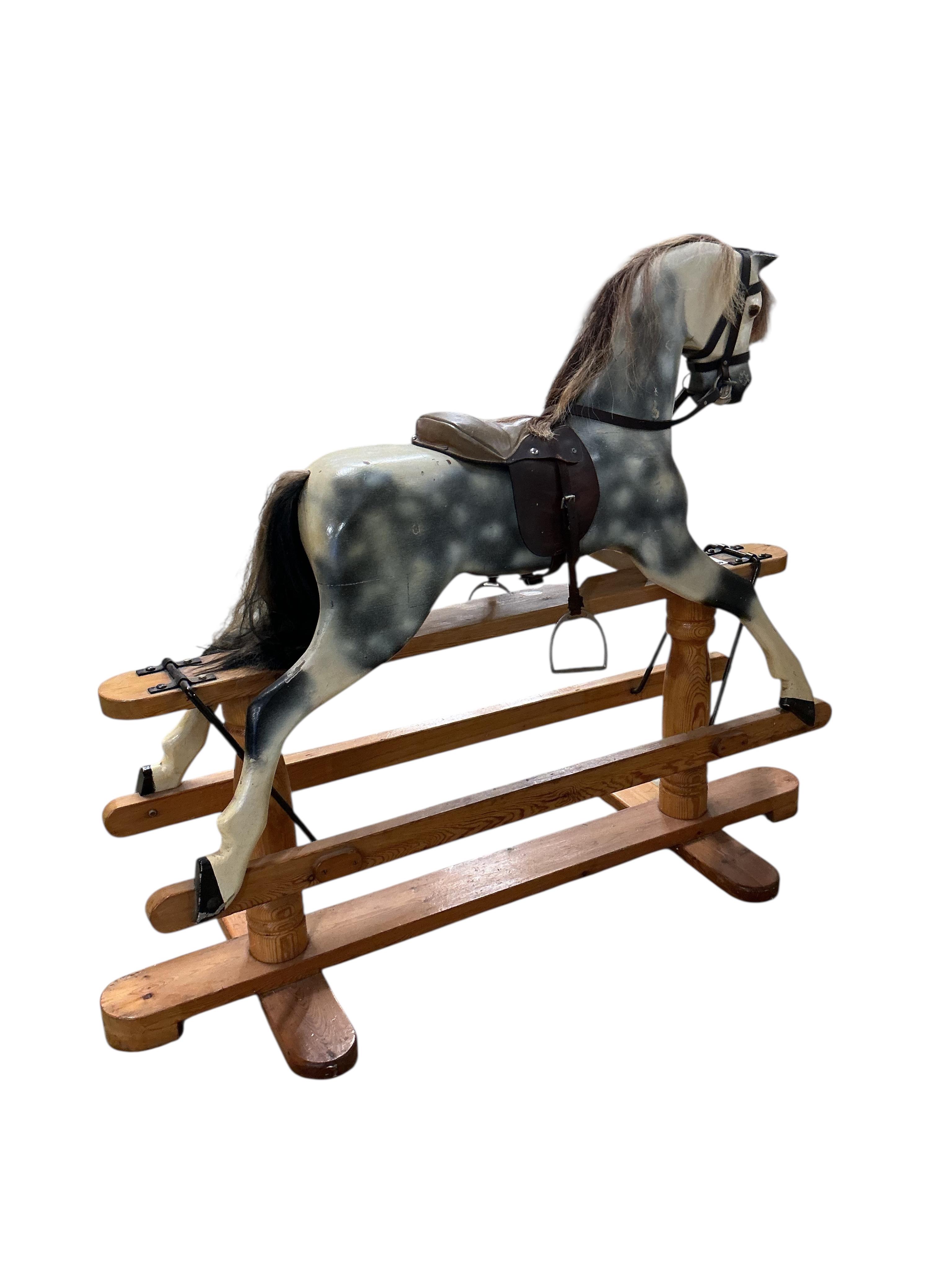 A modern dapple grey rocking horse, unsigned, on a pine base, height to the top of the head 109cm, overall length 136cm